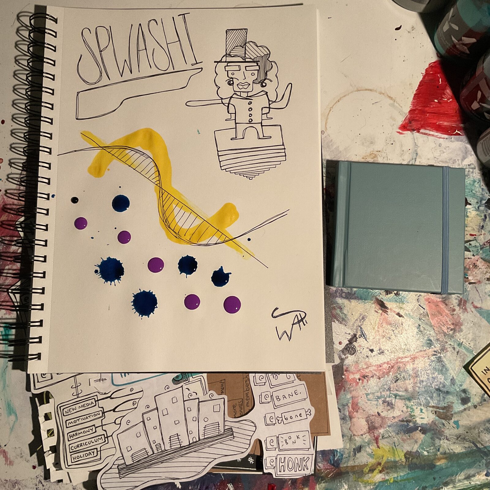 Sketchbook page with Spwashi lettering, a yellow ribbon form, and purple-blue dots on a paint-stained worktable.